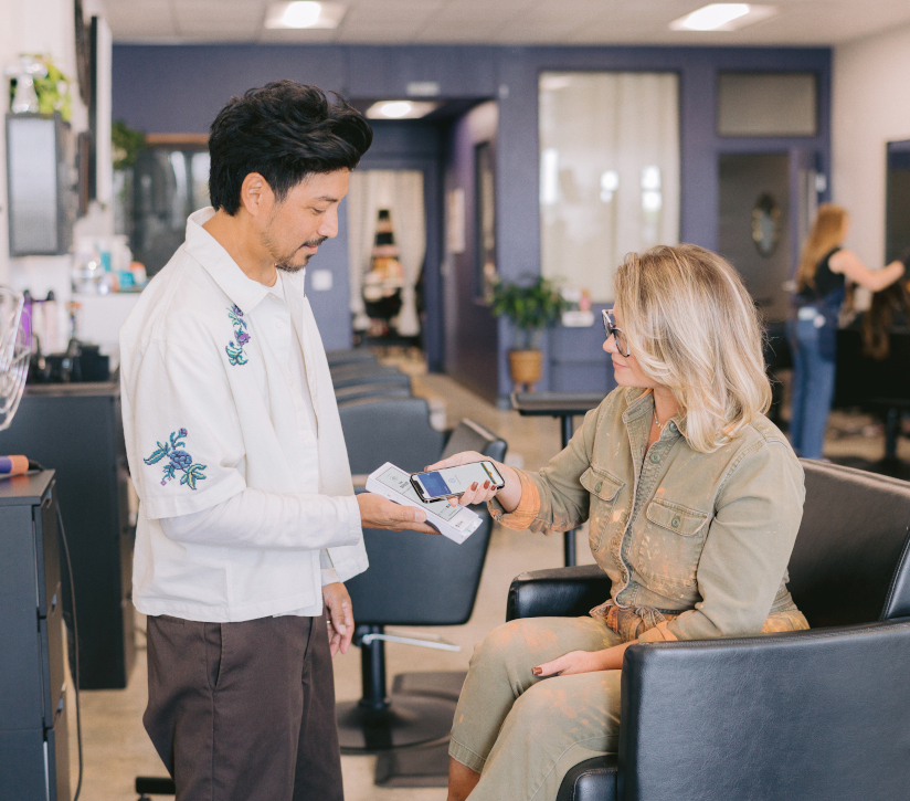 Stylist taking payment on a clover flex pocket