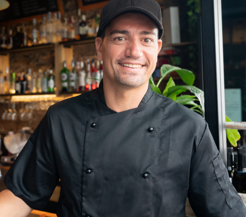 man in chef's outfit in front of bar